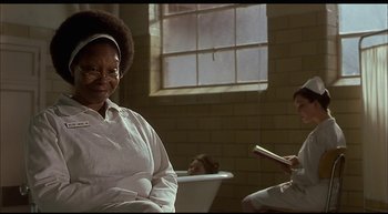 Movie still from “Girl, Interrupted” (1999), directed by James Mangold – An older woman sitting in front of a window in a bathroom; Medium shot, Over the shoulder angle