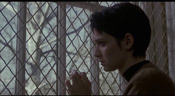 Movie still from “Girl, Interrupted” (1999), directed by James Mangold – A person standing in front of a window holding something; Close Up shot, Low angle