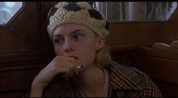 Movie still from “Girl, Interrupted” (1999), directed by James Mangold – A young woman wearing a hat and holding a pen; Close Up shot, High angle