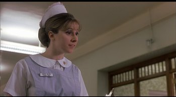 Movie still from “Girl, Interrupted” (1999), directed by James Mangold – A woman in a nurse's uniform is holding something in her hand; Close Up shot, Low angle