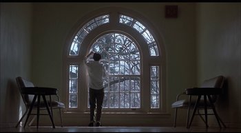 Movie still from “Girl, Interrupted” (1999), directed by James Mangold – A man standing in front of a large window; Wide shot, Low angle