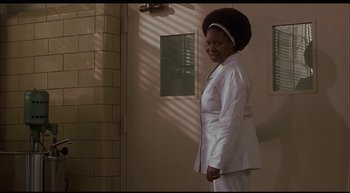 Movie still from “Girl, Interrupted” (1999), directed by James Mangold – A woman standing in a room wearing a white suit; Medium shot, Low angle