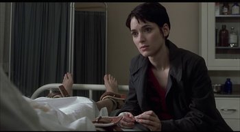 Movie still from “Girl, Interrupted” (1999), directed by James Mangold – A woman sitting in a hospital bed with her feet on the ground; Close Up shot, High angle