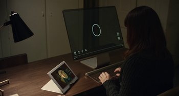 Movie still from “Black Mirror” (2011), created by Charlie Brooker – A woman sitting in front of a computer monitor; Medium shot, High angle