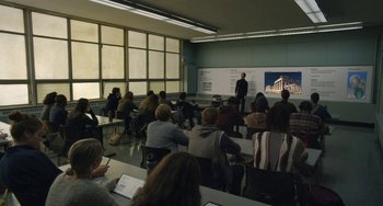 A group of people sitting in front of a white board
