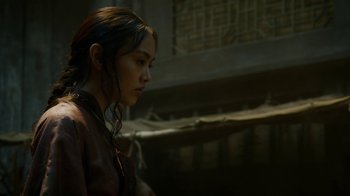 Movie still from “Game of Thrones” (2011), created by D.B. Weiss – A young woman in a leather jacket looking down; Close Up shot, Low angle