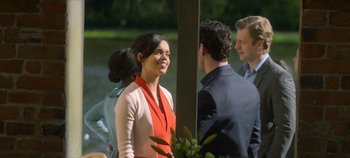 Movie still from “Black Mirror” (2011), created by Charlie Brooker – A group of people standing next to each other near a body of water; Medium shot, Over the shoulder angle