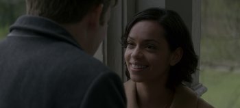 Movie still from “Black Mirror” (2011), created by Charlie Brooker – A young woman smiles at a young man; Close Up shot, Over the shoulder angle