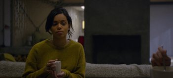 Movie still from “Black Mirror” (2011), created by Charlie Brooker – A woman in a yellow sweater holding a white cup; Medium shot, High angle