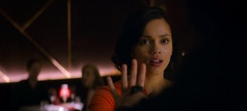 Movie still from “Black Mirror” (2011), created by Charlie Brooker – A young woman making a hand gesture with her hand; Close Up shot, Over the shoulder angle