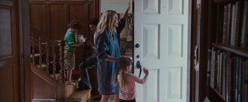 Movie still from “Greenberg” (2010), directed by Noah Baumbach – A woman and a child standing in front of a white door; Medium shot, Over the shoulder angle