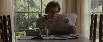 Movie still from “Greenberg” (2010), directed by Noah Baumbach – A man sitting at a table reading a newspaper; Medium shot, Low angle