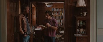 Movie still from “Greenberg” (2010), directed by Noah Baumbach – A man standing in front of a book shelf; Medium shot, High angle