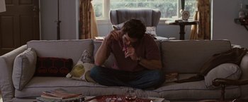 Movie still from “Greenberg” (2010), directed by Noah Baumbach – A man sitting on a couch holding a toothbrush in his mouth; Medium shot, High angle
