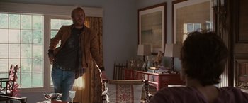 Movie still from “Greenberg” (2010), directed by Noah Baumbach – A man standing in front of a chair in a living room; Medium shot, Over the shoulder angle