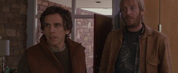 Movie still from “Greenberg” (2010), directed by Noah Baumbach – Two men standing next to each other in front of a brick wall; Medium shot, Over the shoulder angle