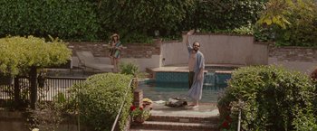 Movie still from “Greenberg” (2010), directed by Noah Baumbach – A man standing next to a swimming pool; Wide shot, High angle