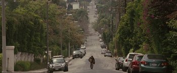 Movie still from “Greenberg” (2010), directed by Noah Baumbach – A person walking down a street holding a bag; Extreme Wide shot, High angle