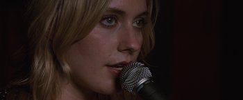 Movie still from “Greenberg” (2010), directed by Noah Baumbach – A person holding a microphone up to their face; Close Up shot, Over the shoulder angle