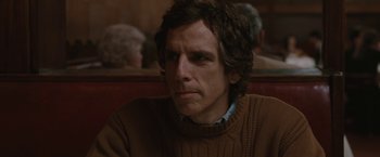 Movie still from “Greenberg” (2010), directed by Noah Baumbach – Ben stiller in a brown sweater in front of a group of people; Close Up shot, Over the shoulder angle