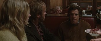 Movie still from “Greenberg” (2010), directed by Noah Baumbach – A group of people sitting in a row of seats; Medium shot, Over the shoulder angle