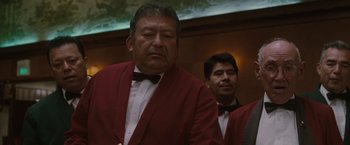 Movie still from “Greenberg” (2010), directed by Noah Baumbach – A man in a red jacket and a man in a black bow tie; Medium shot, Over the shoulder angle