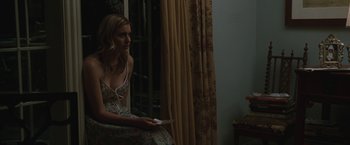 Movie still from “Greenberg” (2010), directed by Noah Baumbach – A woman sitting on a window sill holding a remote control; Medium shot, Over the shoulder angle