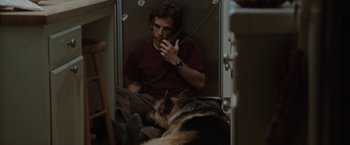 Movie still from “Greenberg” (2010), directed by Noah Baumbach – A man sitting in a chair next to a dog; Medium shot, High angle