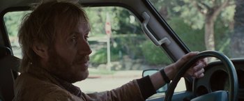 Movie still from “Greenberg” (2010), directed by Noah Baumbach – A man sitting in the drivers seat of a car; Close Up shot, Over the shoulder angle
