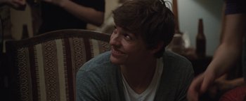 Movie still from “Greenberg” (2010), directed by Noah Baumbach – A young man with a beard smiling for the camera; Close Up shot, Over the shoulder angle
