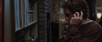 Movie still from “Greenberg” (2010), directed by Noah Baumbach – A man in a brown sweater talking on a phone; Medium shot, Over the shoulder angle