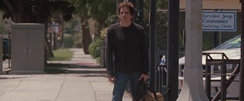 Movie still from “Greenberg” (2010), directed by Noah Baumbach – A man walking down the street holding a bag; Medium shot, Low angle