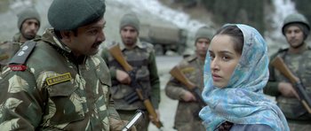 Movie still from “Haider” (2014), directed by Vishal Bhardwaj – A group of people standing next to each other on a street; Close Up shot, Over the shoulder angle