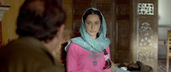 Movie still from “Haider” (2014), directed by Vishal Bhardwaj – A woman in a pink shirt with a blue head scarf; Close Up shot, Over the shoulder angle