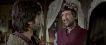 Movie still from “Haider” (2014), directed by Vishal Bhardwaj – Two men are standing in a room talking to each other; Close Up shot, Over the shoulder angle