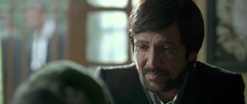 Movie still from “Haider” (2014), directed by Vishal Bhardwaj – A person wearing a suit and tie; Close Up shot, Over the shoulder angle