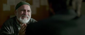 Movie still from “Haider” (2014), directed by Vishal Bhardwaj – An old man with a beard and a green hat; Close Up shot, Over the shoulder angle