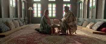Movie still from “Haider” (2014), directed by Vishal Bhardwaj – A man and a woman sitting on the floor in front of stained glass windows; Wide shot, Low angle