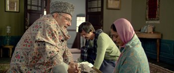 Movie still from “Haider” (2014), directed by Vishal Bhardwaj – A group of people sitting around a table; Medium shot, Low angle
