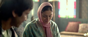 Movie still from “Haider” (2014), directed by Vishal Bhardwaj – A woman wearing a pink headscarf is smiling; Close Up shot, Over the shoulder angle
