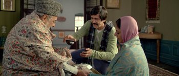 Movie still from “Haider” (2014), directed by Vishal Bhardwaj – A group of people sitting around a table; Medium shot, Low angle