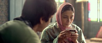 Movie still from “Haider” (2014), directed by Vishal Bhardwaj – A woman wearing a headscarf looking at a cell phone; Close Up shot, Over the shoulder angle