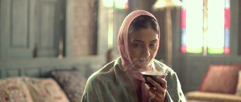 Movie still from “Haider” (2014), directed by Vishal Bhardwaj – A woman in a pink head scarf is holding a cup of coffee; Close Up shot, Low angle