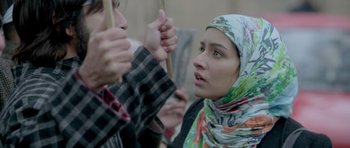 Movie still from “Haider” (2014), directed by Vishal Bhardwaj – A woman in a head scarf is holding a wooden stick; Close Up shot, Low angle