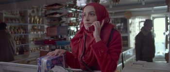 Movie still from “Haider” (2014), directed by Vishal Bhardwaj – A woman in a red coat talking on a phone; Medium shot, Low angle