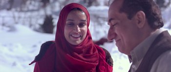 Movie still from “Haider” (2014), directed by Vishal Bhardwaj – A woman wearing a red headscarf smiling at a man in the snow; Close Up shot, Over the shoulder angle
