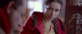 Movie still from “Haider” (2014), directed by Vishal Bhardwaj – A woman with a braid in her hair wearing a red jacket; Close Up shot, Over the shoulder angle