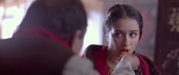 Movie still from “Haider” (2014), directed by Vishal Bhardwaj – A young woman eating a piece of food while a man watches; Close Up shot, Over the shoulder angle