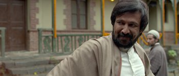 Movie still from “Haider” (2014), directed by Vishal Bhardwaj – A man with long hair and a beard is smiling; Close Up shot, Low angle