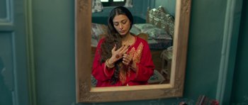 Movie still from “Haider” (2014), directed by Vishal Bhardwaj – A woman in a red dress is looking at her hair; Close Up shot, Overhead angle